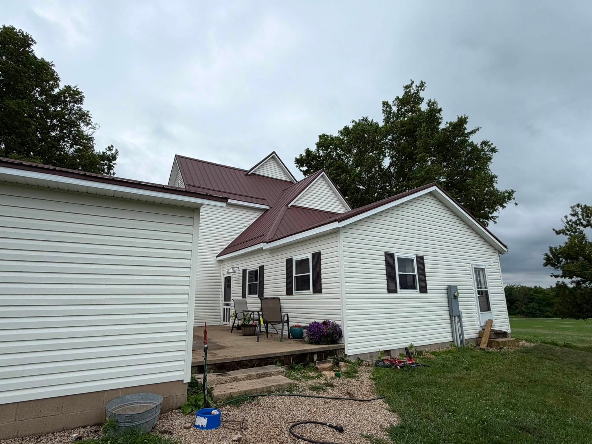 Farmhouse side elevation with brown metal roof and siding