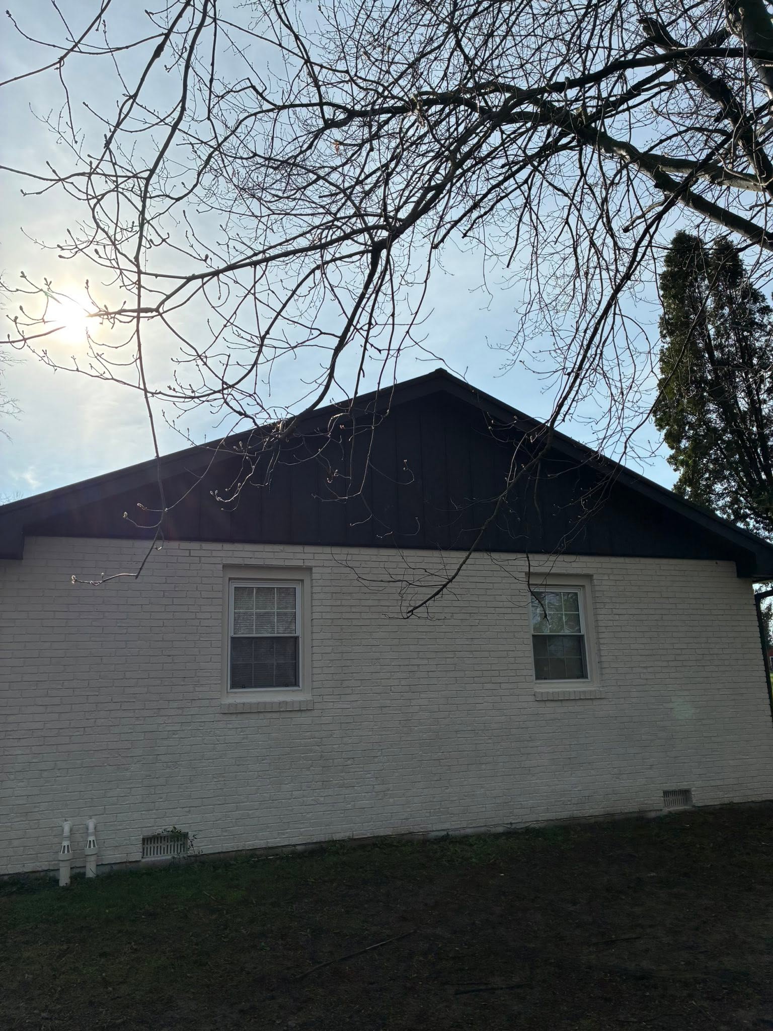 White home with black metal roof and trim