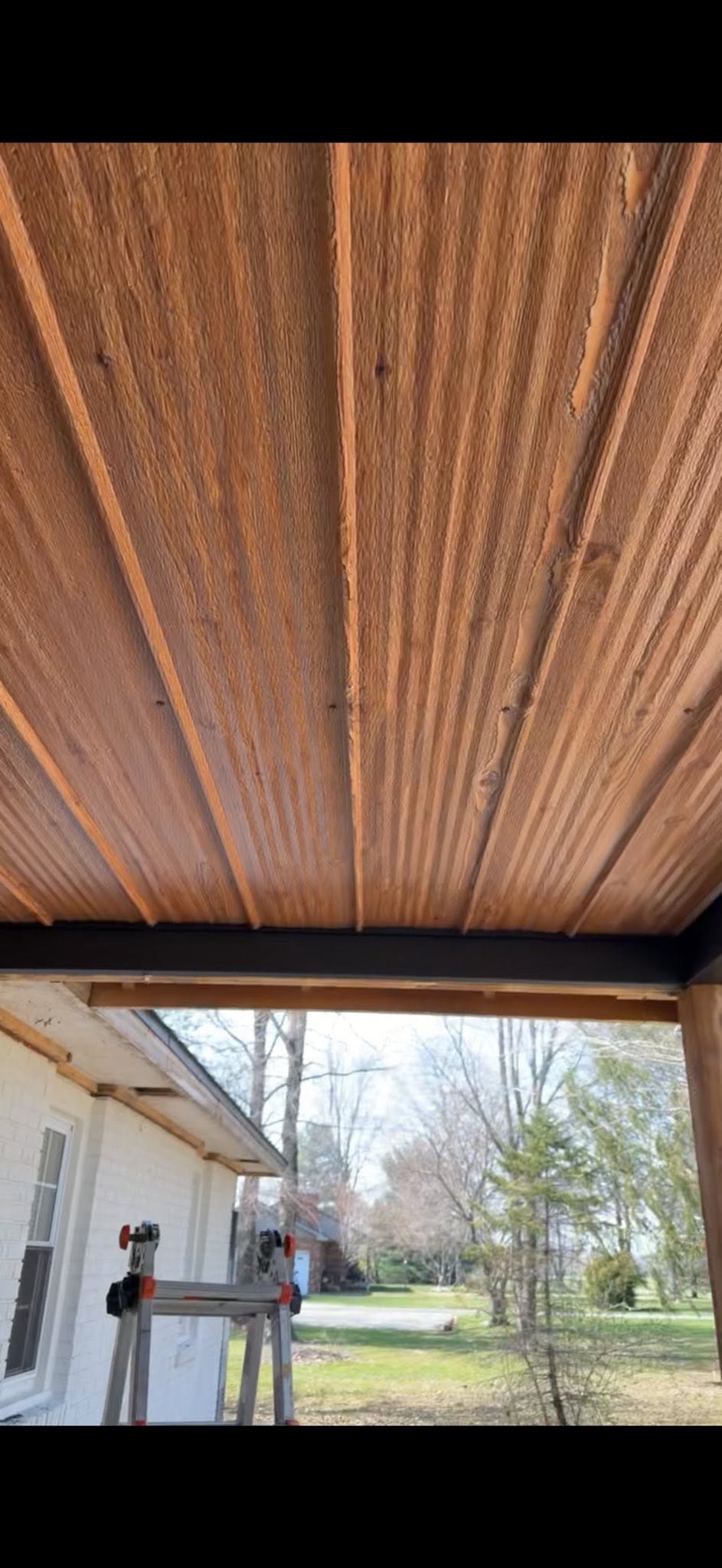 Wood-look soffit finish under a porch roof